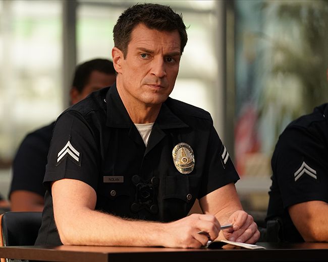 Nathan Fillion sits at table in The Rookie