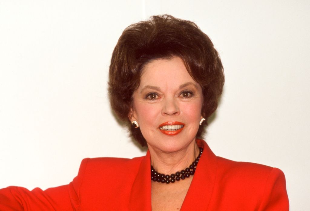 Shirley Temple wearing a red blazer and red lipstick 