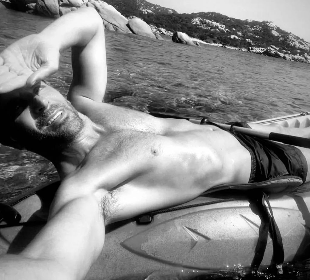 Bradley Cooper is shirtless lying down in a kayak