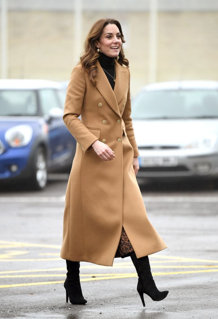 kate walking in camel coat and black boots