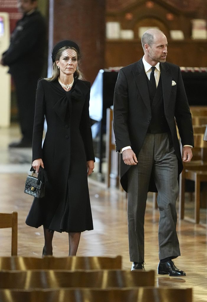 William, Prince of Wales and Catherine, Princess of Wales in cathedral aisle in black