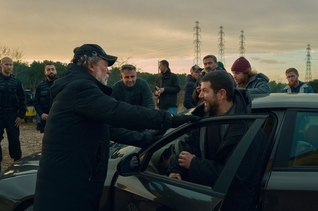 A man being dragged out of a car by another man