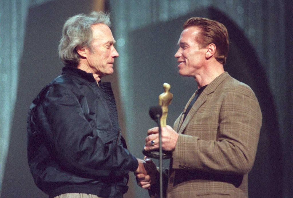 Actors Arnold Schwarzenegger and Clint Eastwood do a mock presentation on stage at the Shrine Auditorium 24 March 1995 in preperation for the 67th Annual Academy Awards, which will take place Monday night 27 March in Los Angeles