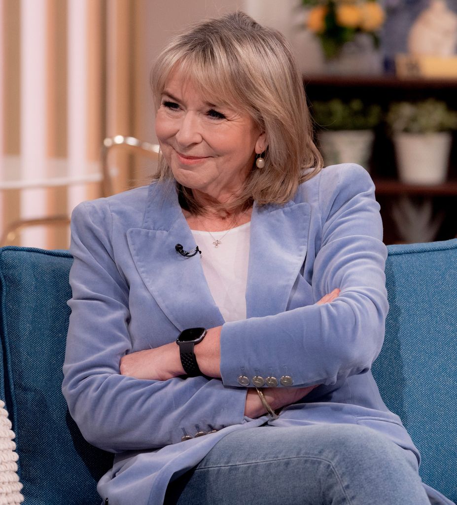 Fern Britton in blue blazer on blue sofa