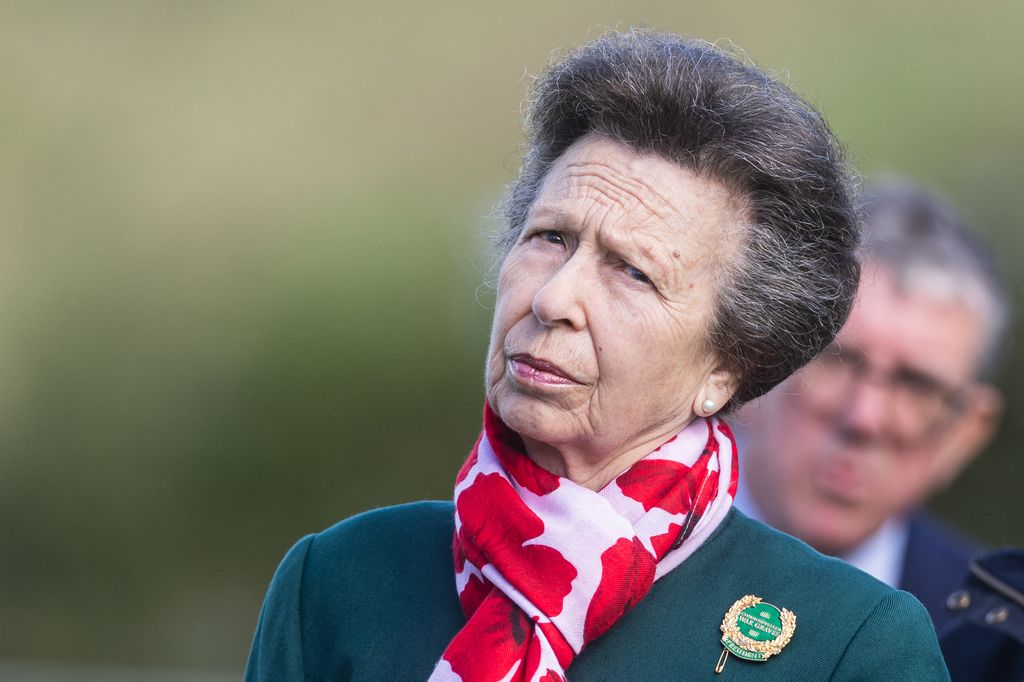 Princess Anne looking perplexed in a green jacket and floral print scarf