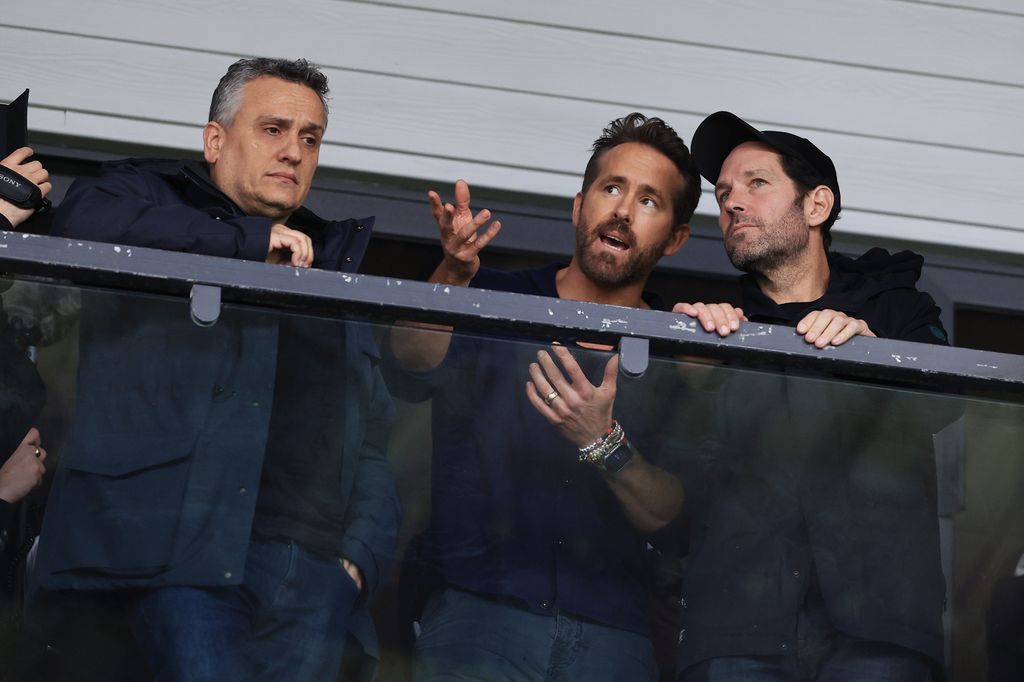 Wrexham co-owner Ryan Reynolds (centre) talks with film director Joe Russo (left) and actor Paul Rudd (right) at the team's yard
