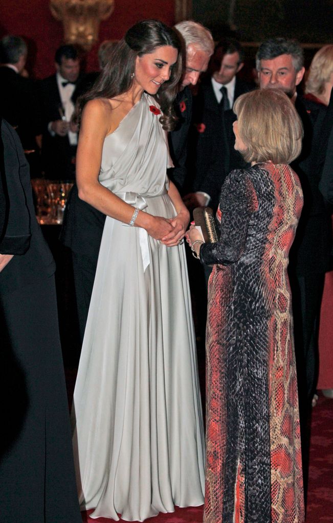 catherine talks to people at a reception in grey gown