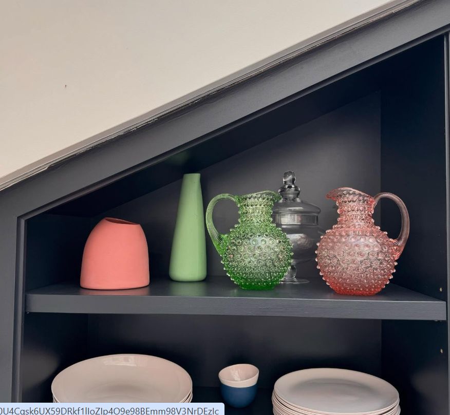 A selection of plates, ramekins and jugs on a black shelving unit