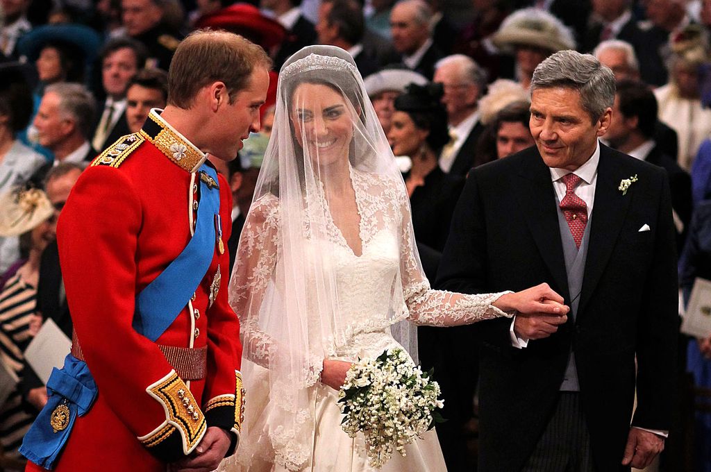 Prince William speaks to his bride Princess Kate and father-in-law Michael Middleton at Westminster Abbey