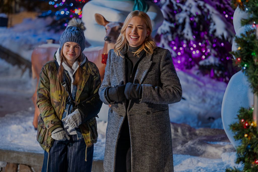 mother and daughter standing next to snow