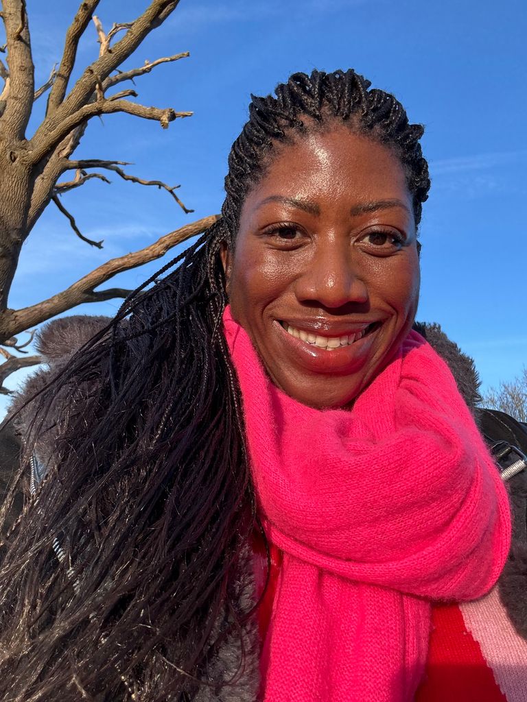 Headshot of Ateh Jewel wearing a bright pink scarf with her skin looking glowing 