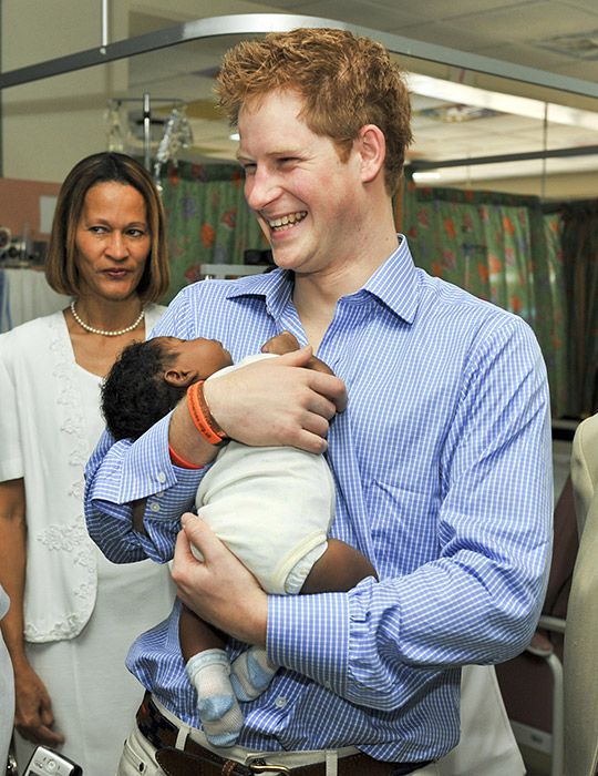 prince harry smiling holding baby
