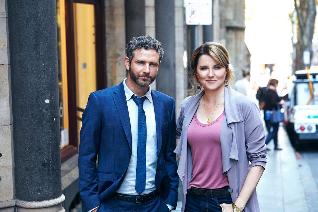 man and woman standing in street smiling