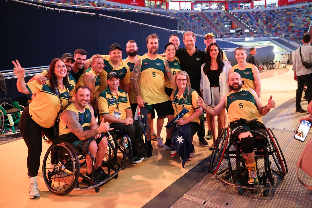 Harry and Meghan pose for a photograph with the Australia team as they attend the wheelchair basketball match between Ukraine and Australia