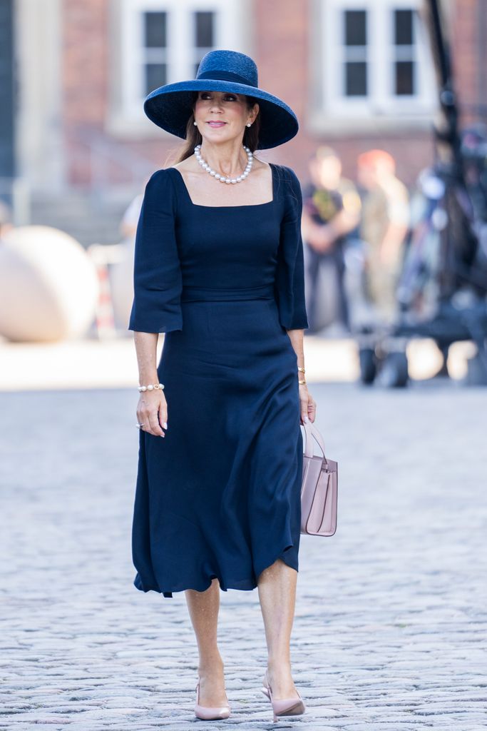 Queen Mary in navy midi dress and hat 