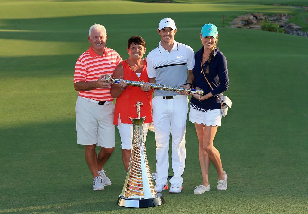 Rory McIlroy stood holding a trophy with Erica and his parents Gerry and Rosie McIlroy