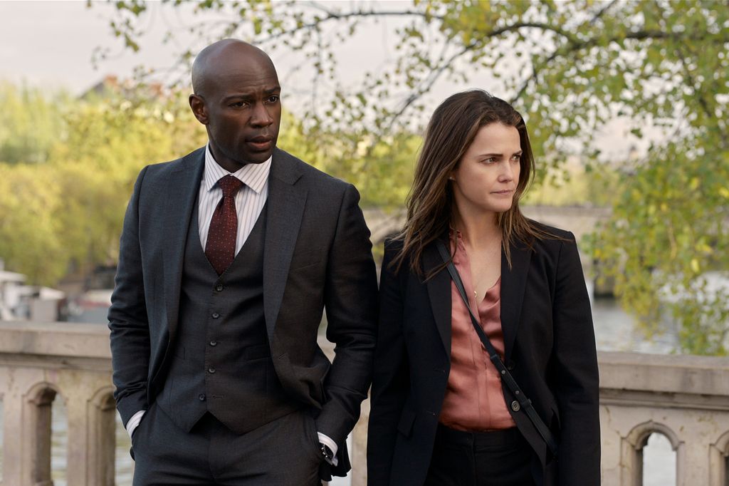 David Gyasi as Austin Dennison and Keri Russell as Kate Wyler stand on bridge in The Diplomat