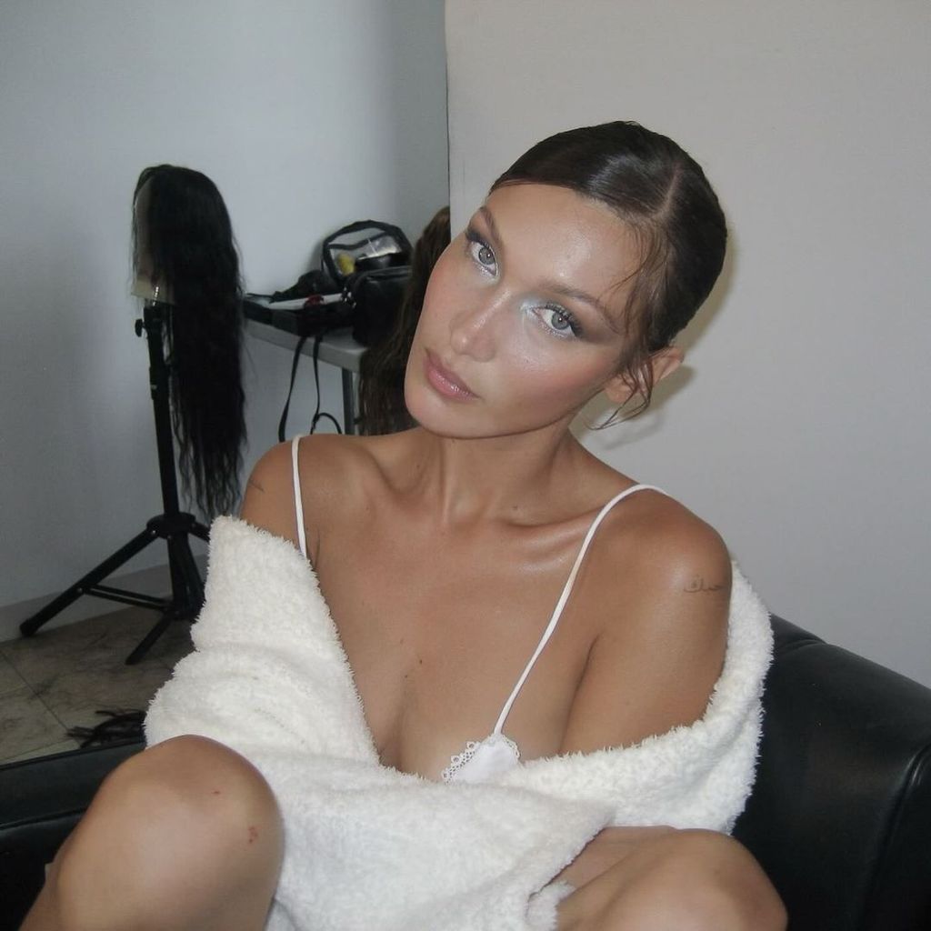 Bella Hadid wearing glittery make up and a white fleece jumper