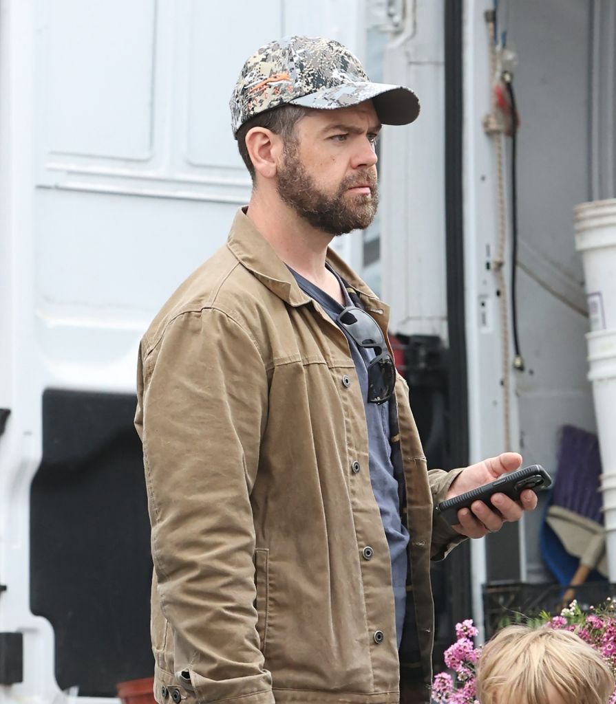 Jack Osbourne in camo cap and beige jacket walking in California 