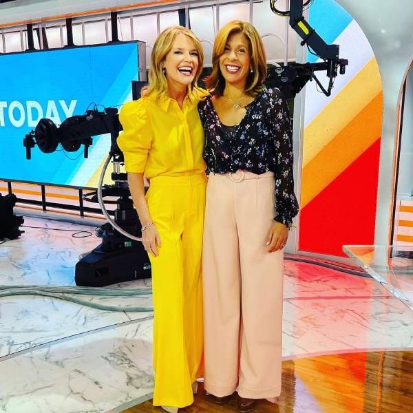 Savannah Guthrie wears bright yellow oufit as she hugs co host Hoda Kotb