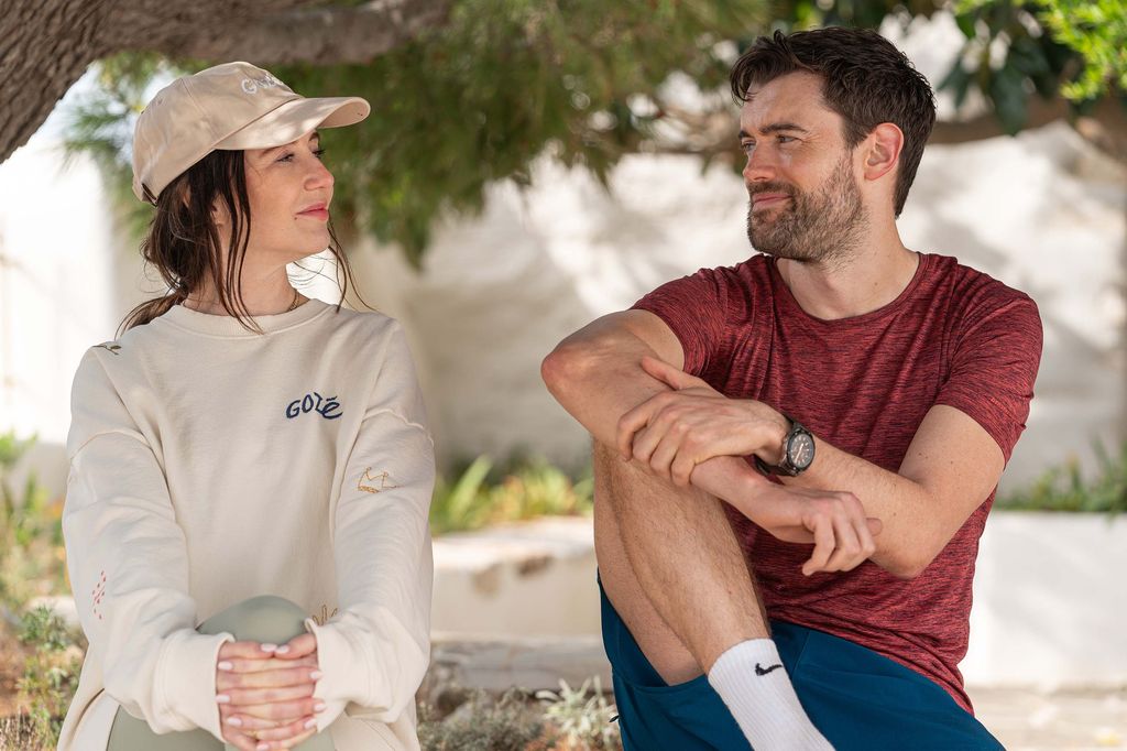 woman and man sitting outdoors by tree