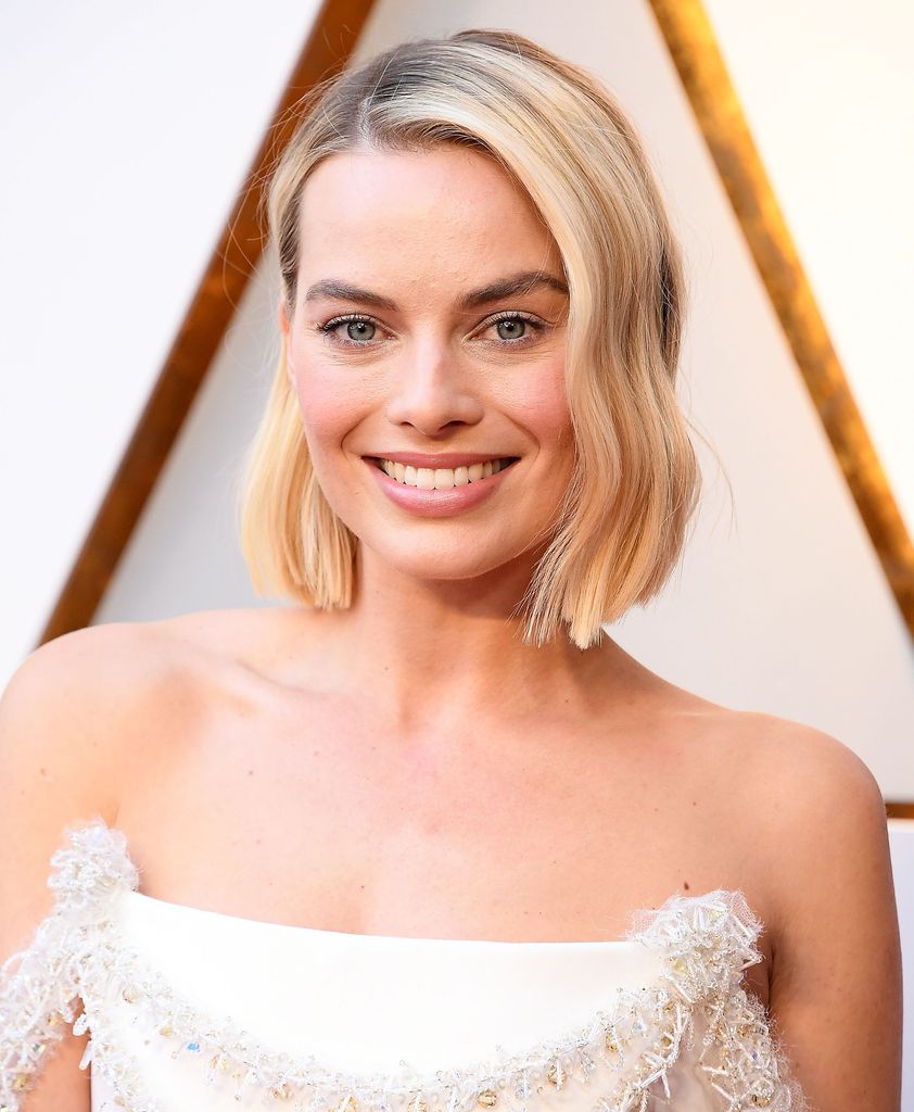 Margot Robbie smiling with blonde bob