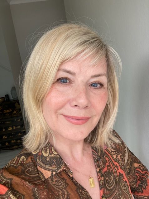 Woman smiling in a brown printed shirt