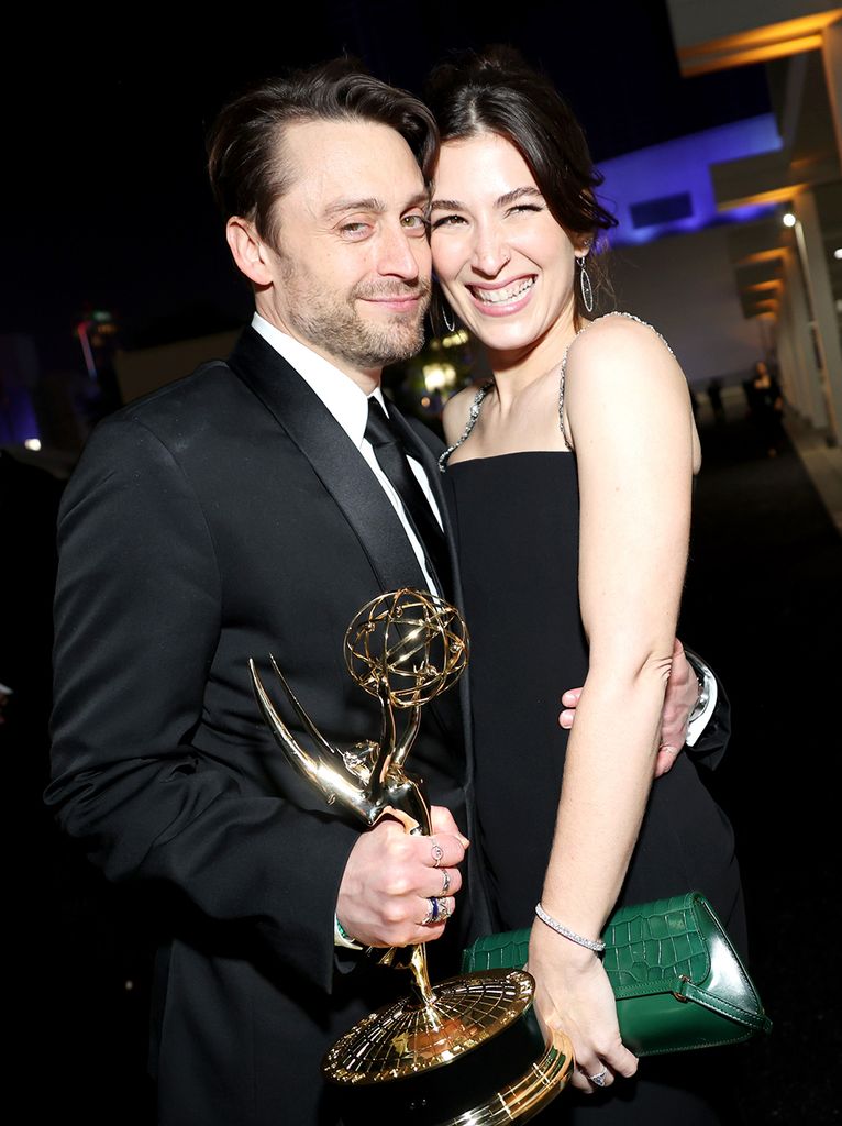Kieran Culkin holding his Emmy with his wife Jazz Charton beside him. 