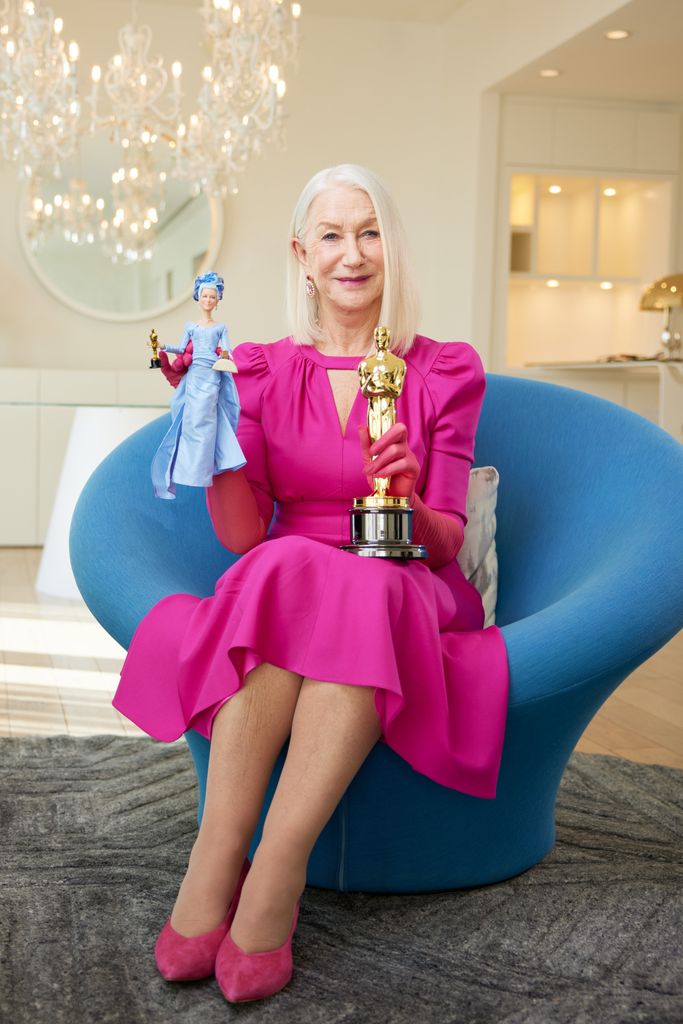 Dame Helen Mirren holding her one-of-a-kind Barbie