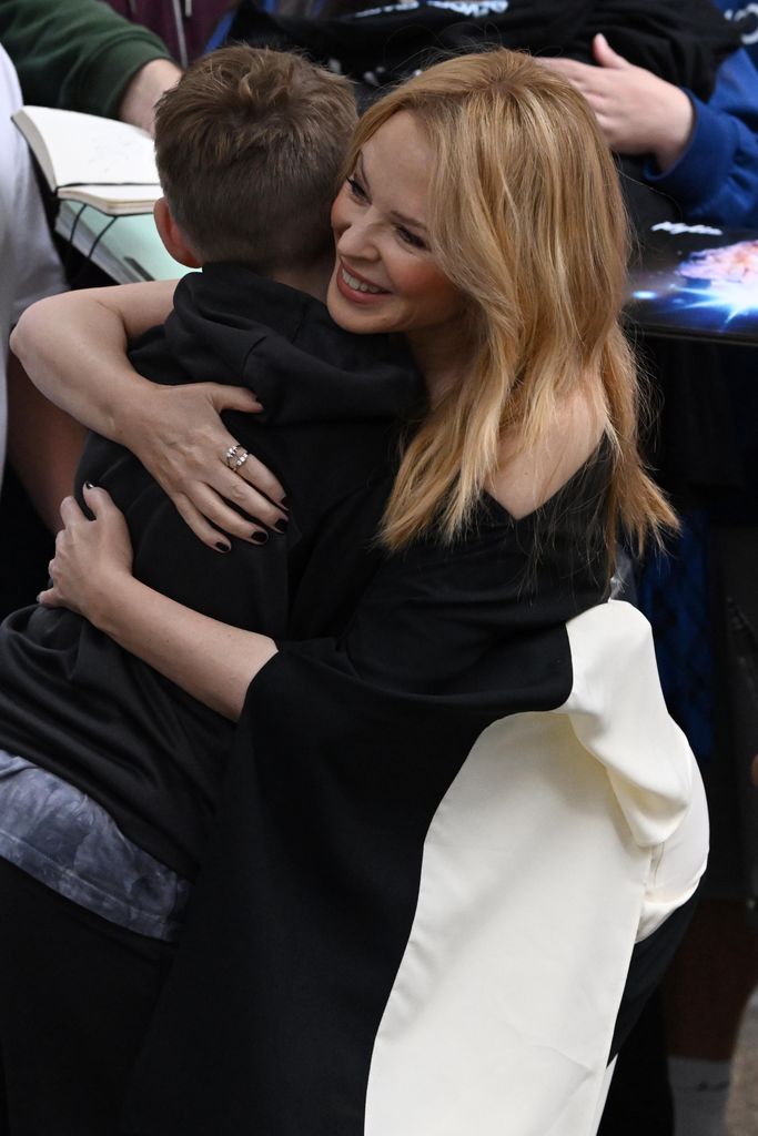 Kylie Minogue hugging a young boy