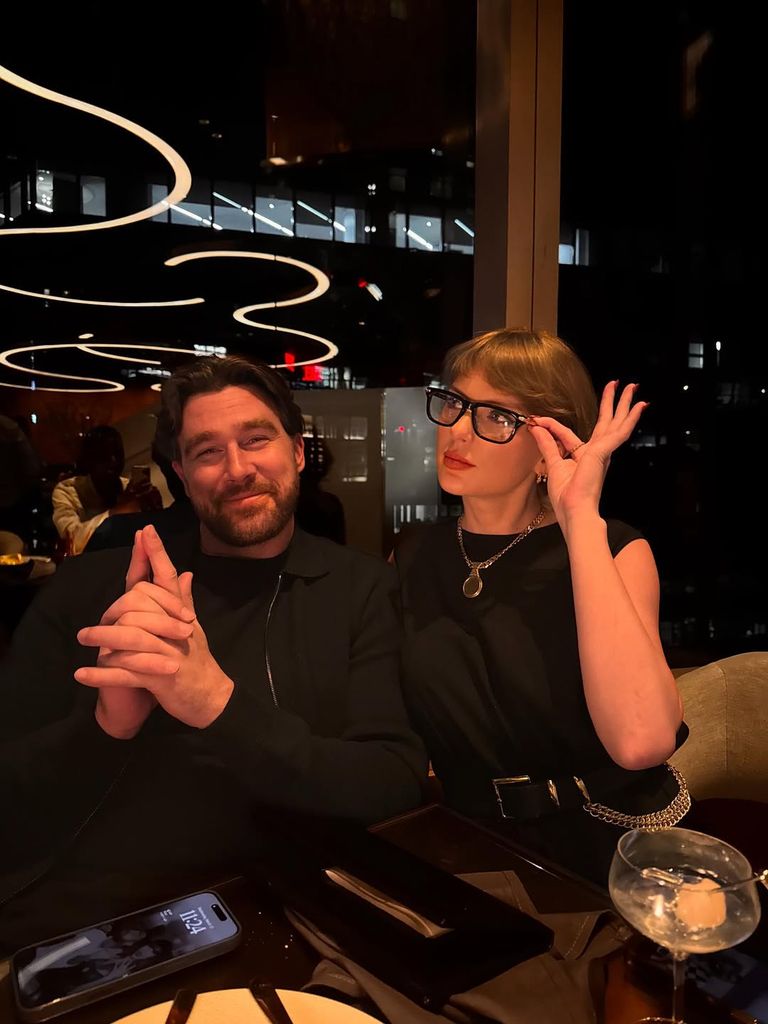 Travis Kelce and Taylor Swift pose for a picture in a restaurant 