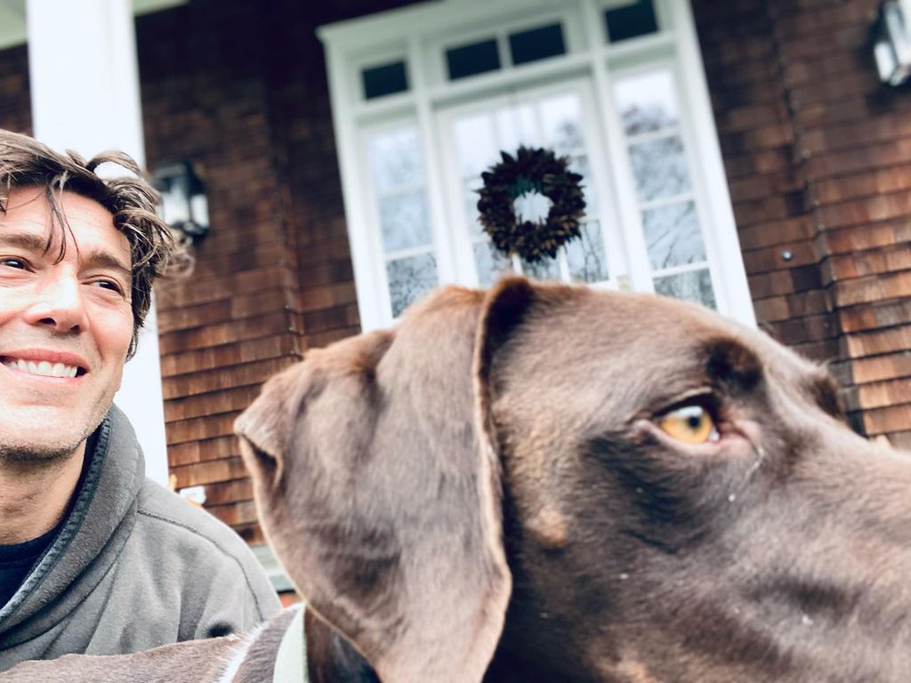 David Muir and his dog Axel sitting outside his NYC home