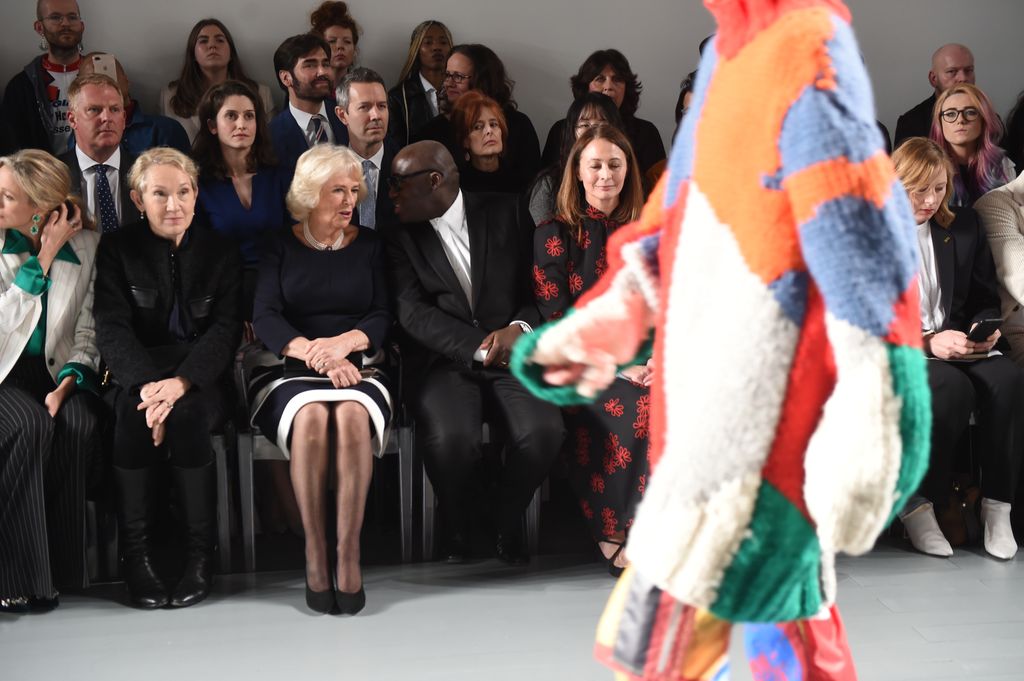 Camilla, Duchess Of Cornwall sits next to editor-in-chief of British Vogue magazine Edward Enninful during the Bethany Williams Sho