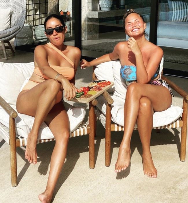 Chrissy Teigen on holiday posing with a friend