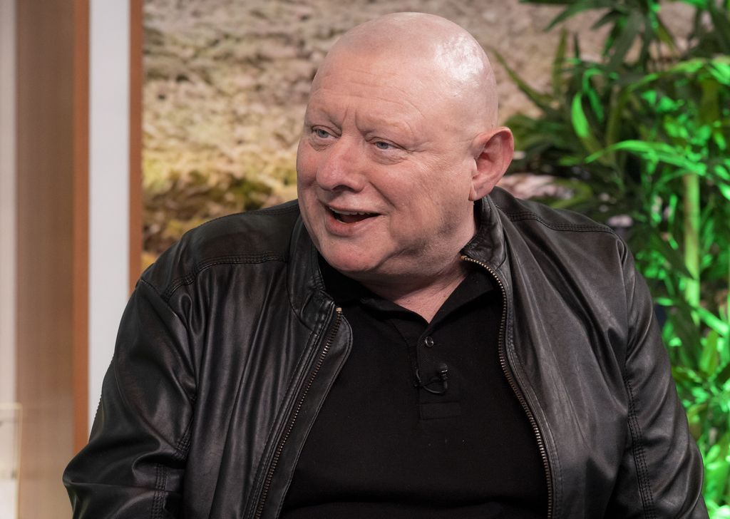 Shaun Ryder smiling in a black leather jacket