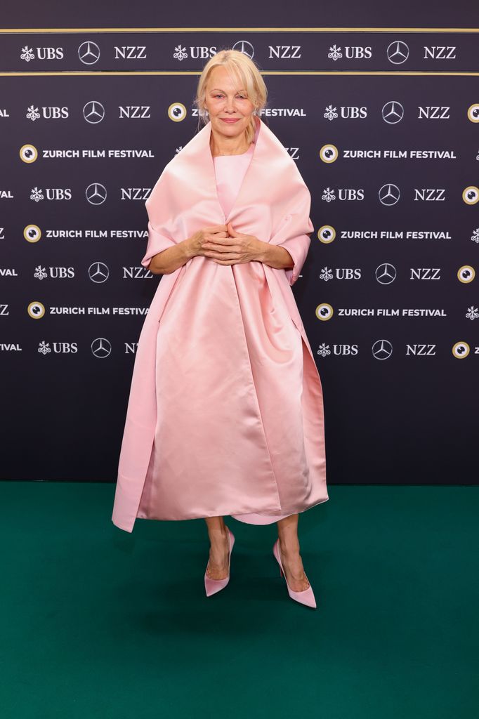 Pamela Anderson on green carpet in pink satin dress