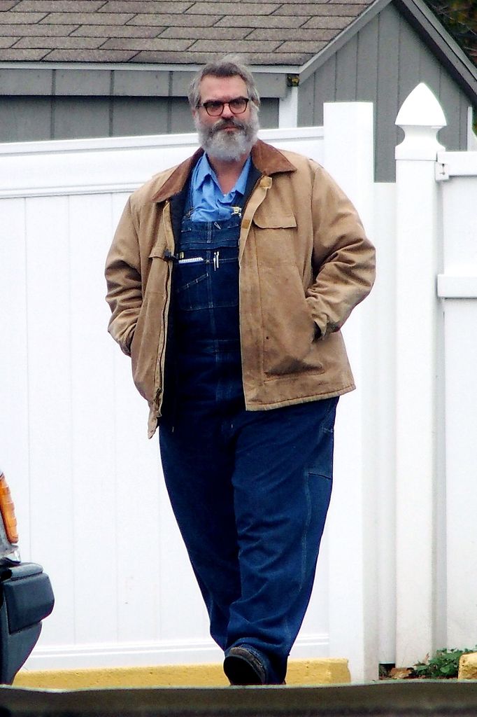 photo of david harbour with grey beard and padded suit wearing overalls