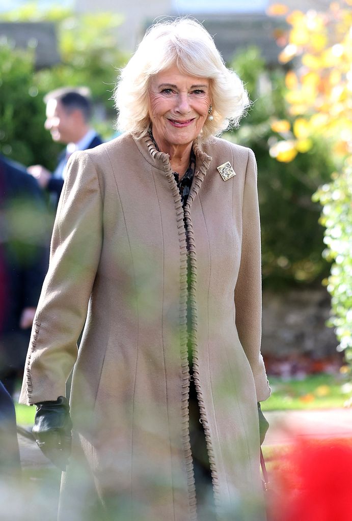 Queen Camilla reacts as she arrives to visit to The Poppy Project in Corsham