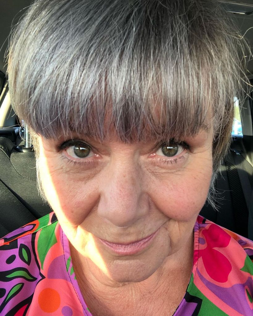 Dawn French showing off grey fringe and colourful top