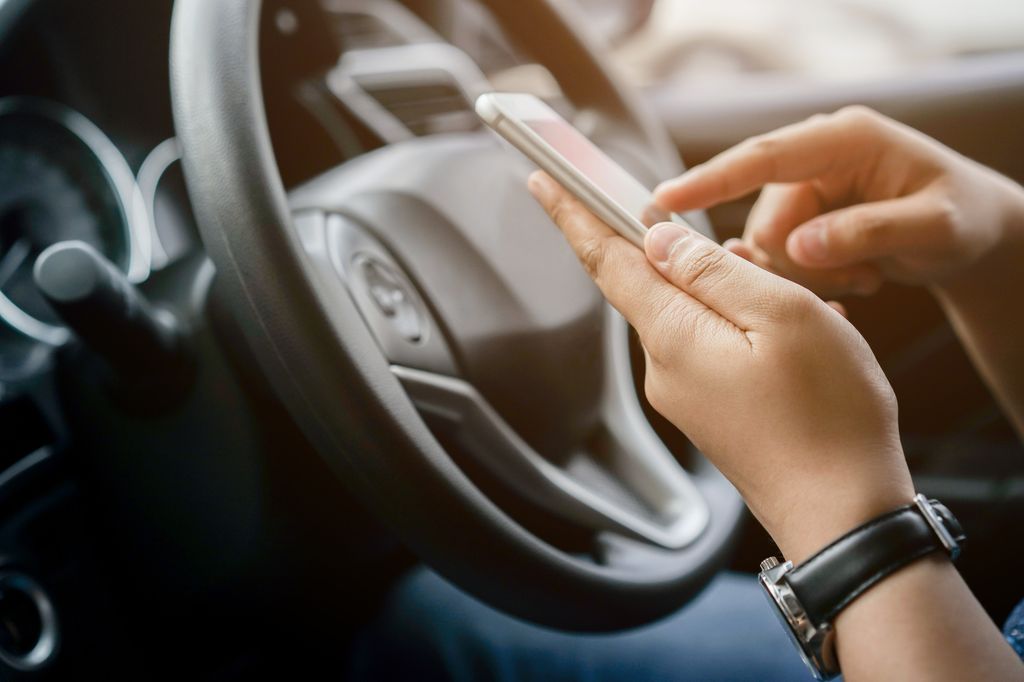 close up driver woman hand holding smartphone in the car