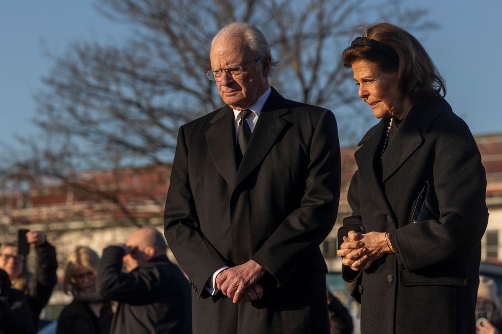 King Carl XVI Gustaf and Queen Silvia light candles at a memorial site to honor the victims of the school shooting on February 5, 2025 in Orebro, Sweden