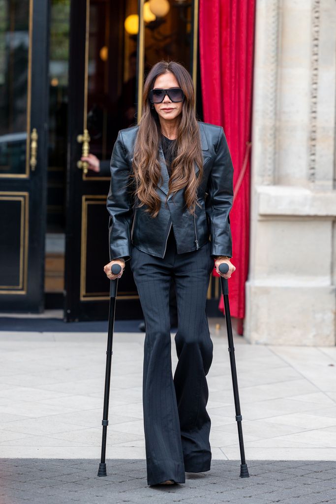 Victoria Beckham walking on crutches in Paris wearing all black 