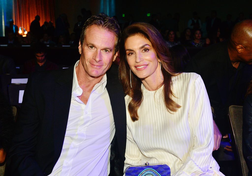 Rande Gerber in a suit and Cindy Crawford in a white dress with a blue bag