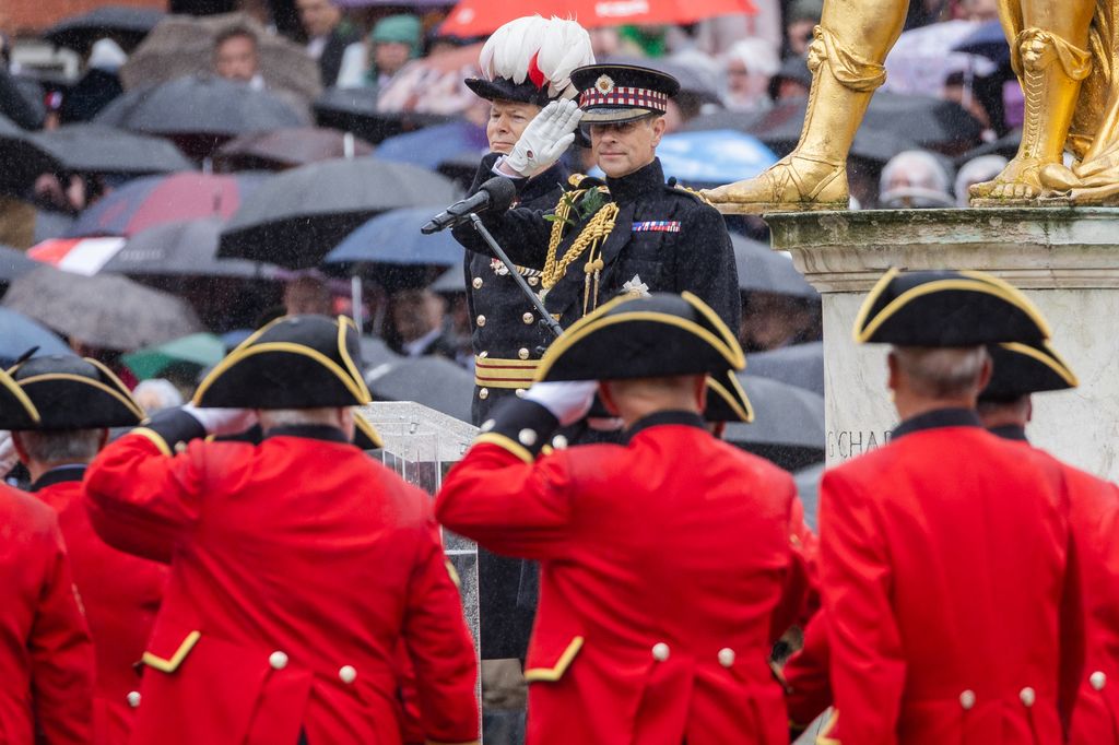Prince Edward salutes in military uniform in the rain