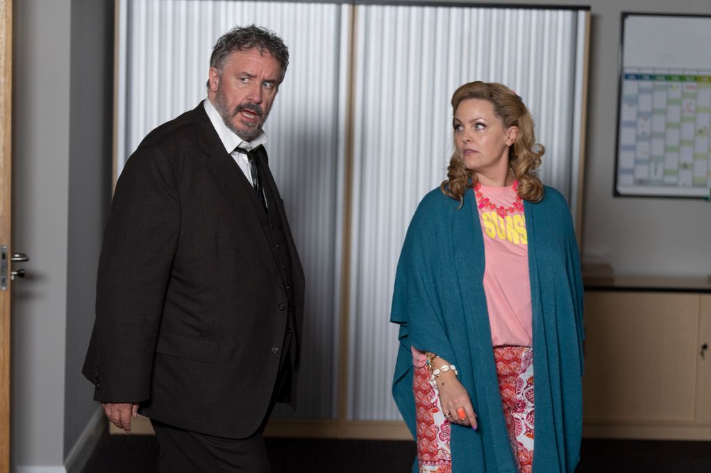 man and woman standing in office