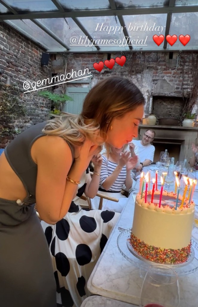 Lily james blowing out candles on a cake