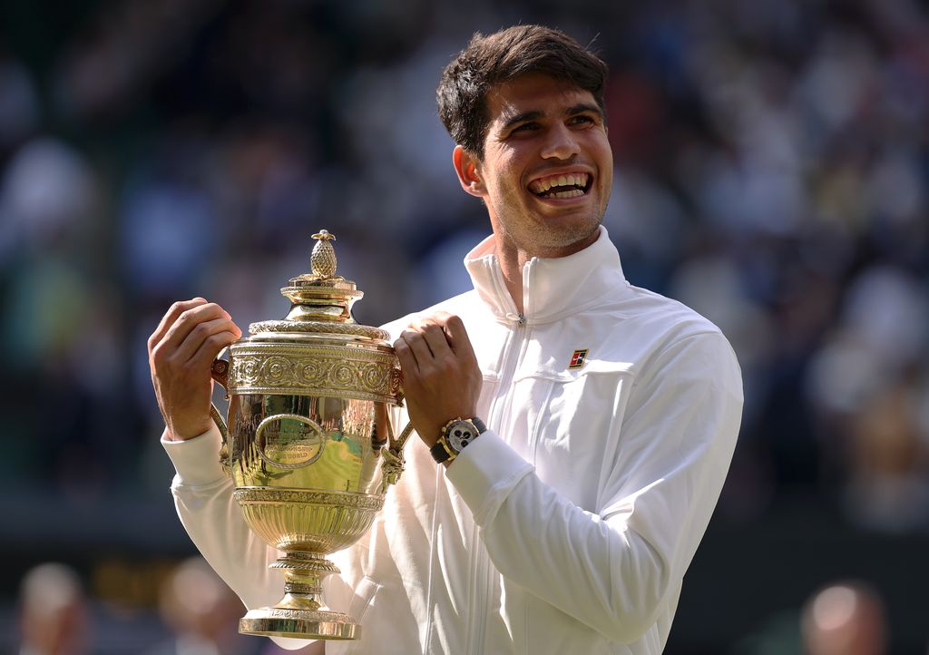 Carlos Alcaraz of Spain celebrates with the trophy after defeating Novak Djokovic of Serbia in the Gentlemen's Singles Final during day fourteen of The Championships Wimbledon 2024 at All England Lawn Tennis and Croquet Club on July 14, 2024 in London, England