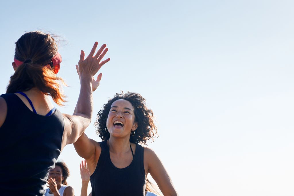 two women high fiving happily