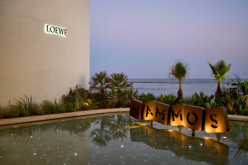 Nammos sign sitting in a pool of water with sparkling lights           