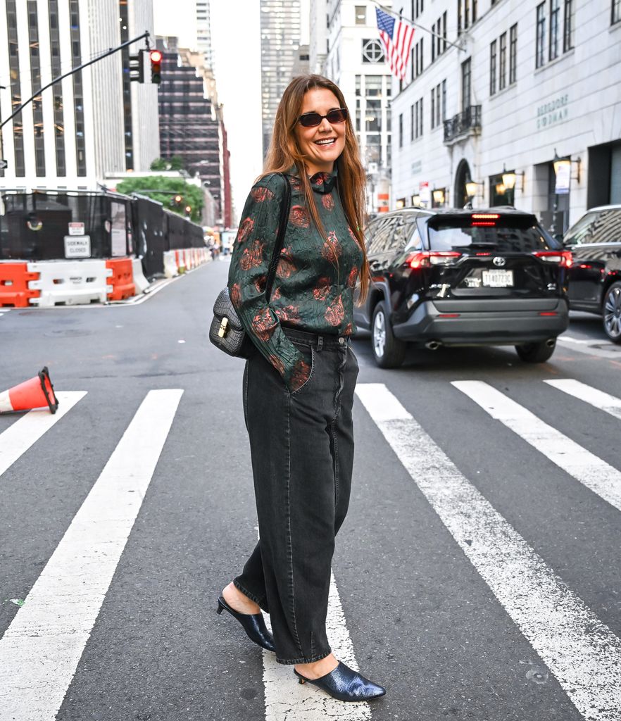 Katie Holmes atravessando a rua de jeans sorrindo